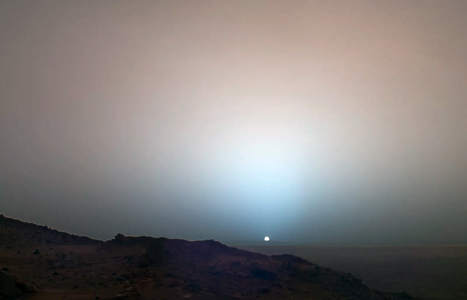 Рассвет на Марсе. Если смотреть с поверхности красной планеты, то она уже не кажется нам такой уж красной. Во всяком случае, небо у неё... голубоватое